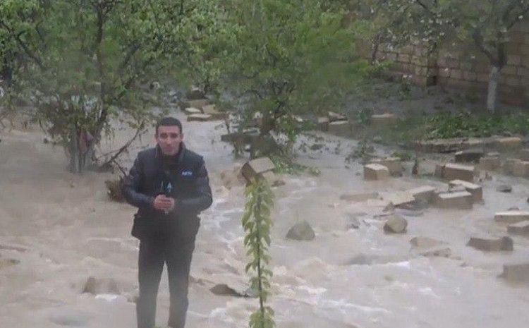 AzTV müxbiri selin ortasından CANLI YAYIMA çıxdı: yağış daş divarı uçurdu - VİDEO